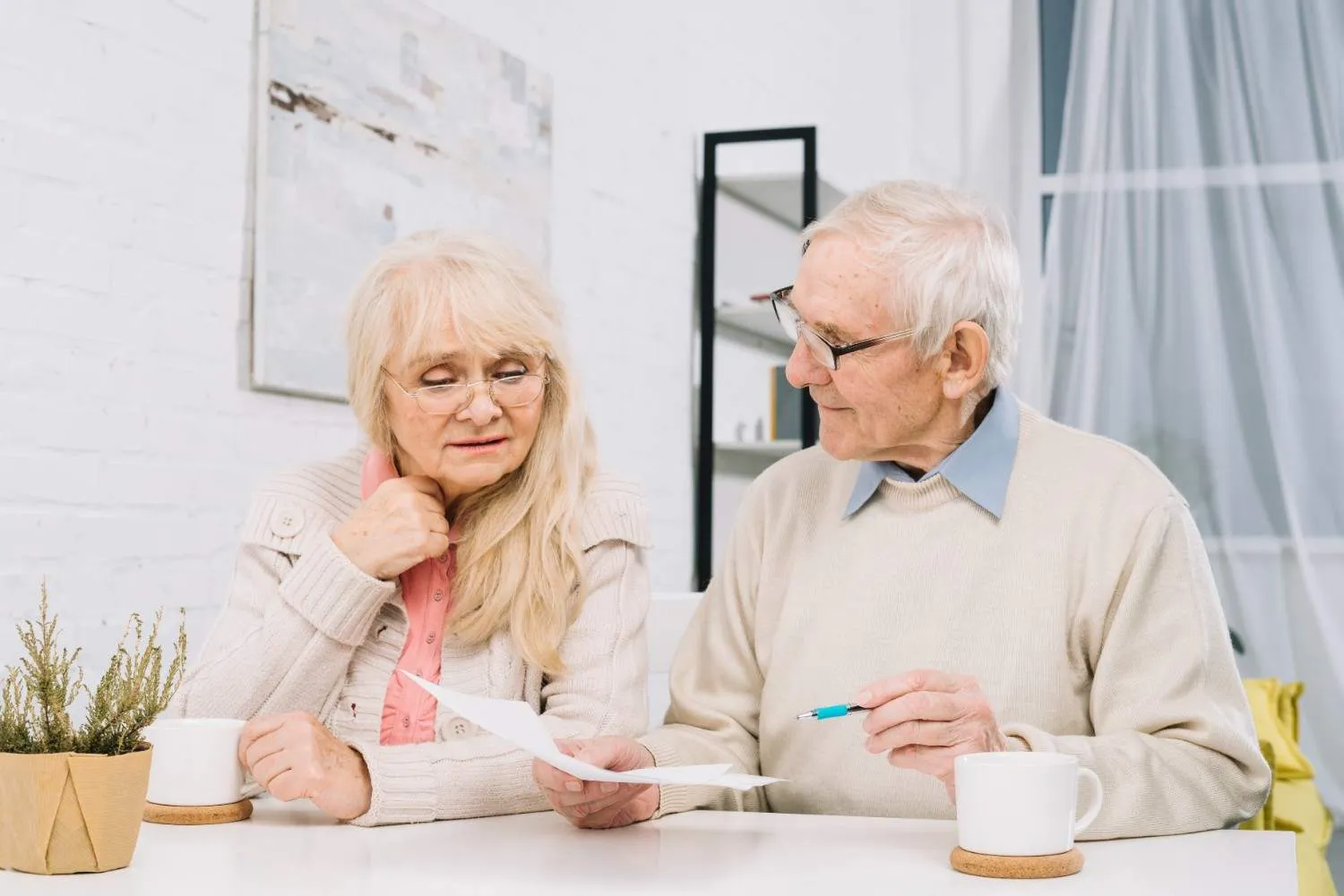 An older couple at their kitchen table going over a Medicare letter together